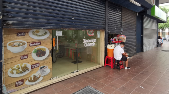 Los locales comerciales en el centro de Guayaquil tienen su persiana metálica parcialmente cerrada para evitar sanciones.