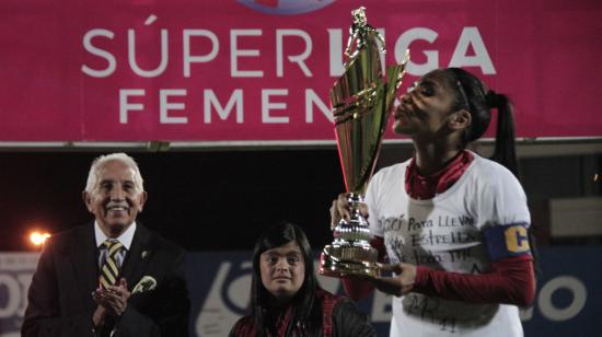 Madelin Riera, jugadora del Deportivo Cuenca, besando el trofeo de la Superliga femenina 2019.