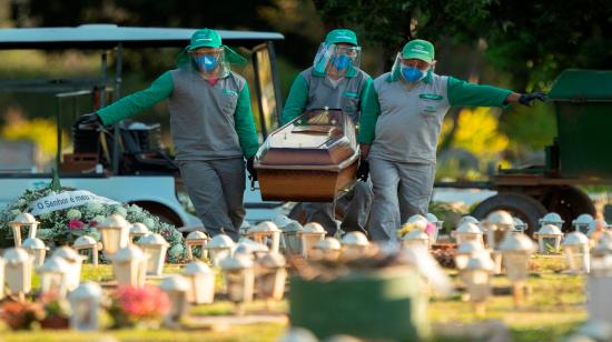 Trabajadores del cementerio Campo de Esperanza entierran a una víctima de Covid-19 el jueves 21 de mayo en Brasilia, Brasil. (América)