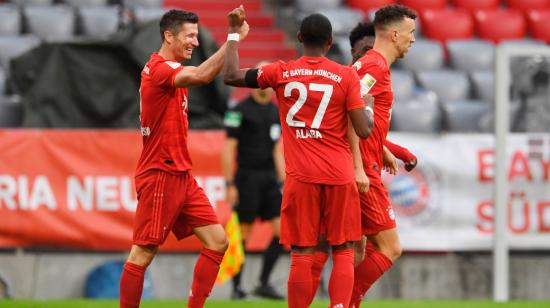 Robert Lewandowski, del Bayern Munich, celebra con su compañero David Alaba un gol en el partido de fútbol de la Bundesliga contra el Eintracht Frankfurt en Munich, el 23 de mayo de 2020.