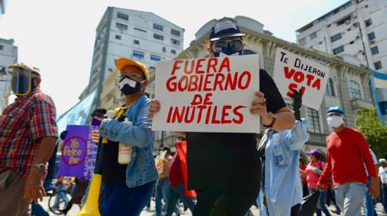 Manifestantes en el centro de Guayaquil portan carteles contra el Gobierno.