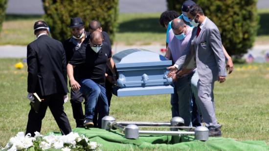 Varias personas cargan un ataúd en un cementerio, el miércoles 27 de mayo, en Massachusetts, Estados Unidos.