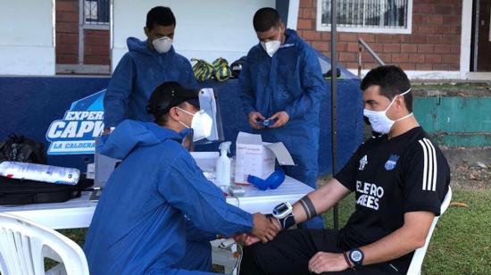 El DT de Emelec, Ismael Rescalvo, tomándose la prueba de Covid-19.