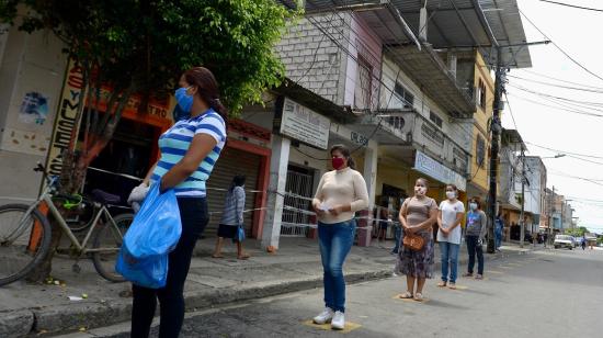 Ciudadanos esperan en línea guardando la distancia mínima para evitar contagios de Covid-19 en Daule, el pasado 12 de mayo. 