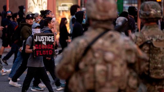 Los manifestantes reaccionan cuando pasan junto a miembros de la Guardia Nacional durante las protestas por la muerte de George Floyd, quien murió bajo custodia policial, en Pershing Square en Los Ángeles, California, el 31 de mayo de 2020