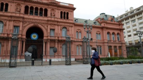 Una mujer que usa una mascarilla como medida preventiva contra la enfermedad del coronavirus, camina frente al Palacio Presidencial Casa Rosada, en Buenos Aires, Argentina, 21 de mayo de 2020.