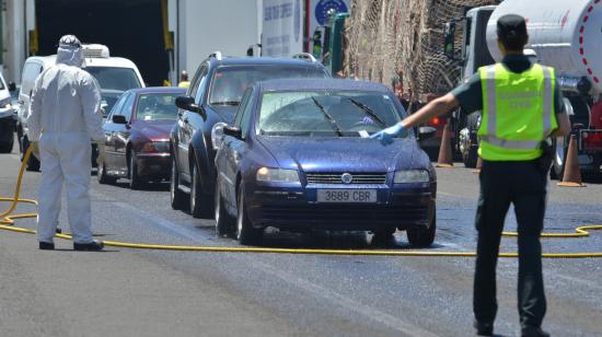 Agentes de la Guardia Civil y operarios del Cabildo de El Hierro realizan labores de control y desinfección, respectivamente, de vehículos procedentes de la isla de Tenerife (España) el viernes 8 de mayo, en el puerto de La Estaca.