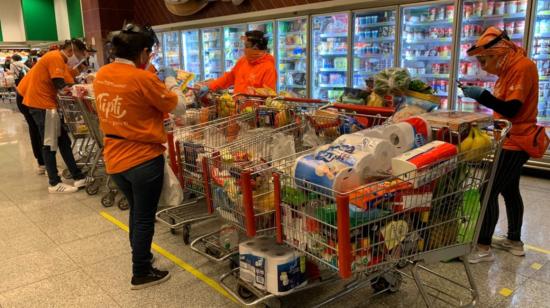 Algunos de los 'shoppers' de la app Tipti en un supermercado de Quito, en junio de 2020.