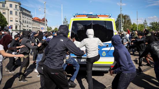 Manifestantes atacan un auto de la policía, el domingo 7 de junio, en Gothenburg, Suecia.