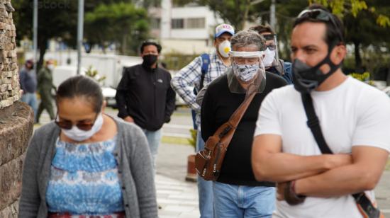 Personas esperan ingresar a un centro comercial de Quito, el 3 de junio de 2020.