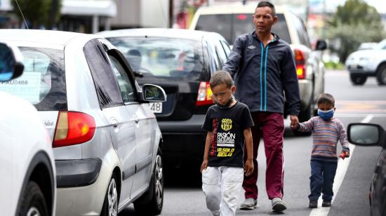 Un ciudadano venezolano y sus dos hijos caminan por una calle en Quito, el jueves 21 de mayo.