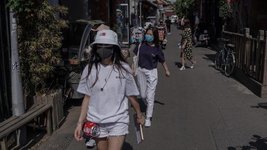 Ciudadanos portando mascarillas caminan por una calle en China, país que detectó dos nuevos casos de Covid-19, el 12 de junio. 