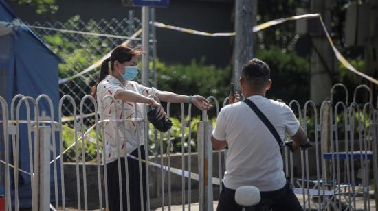 Dos personas conversan en una zona de residencias bloqueada por la autoridad China ante el nuevo brote de Covid-19, el 19 de junio. 