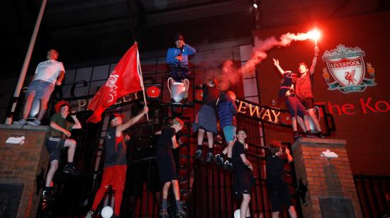 Hinchas del Liverpool festejan el campeonato a las afueras del estadio de Anfield, en Inglaterra, el jueves 25 de junio de 2020.