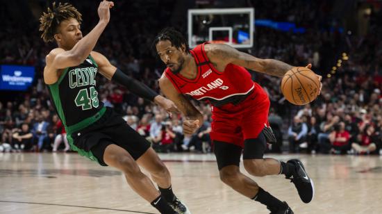 El alero de los Portland Trail Blazers, Trevor Ariza (8) conduce a la canasta durante la segunda mitad contra el guardia de los Boston Celtics, Romeo Langford en el Moda Center, en un partido de la NBA.