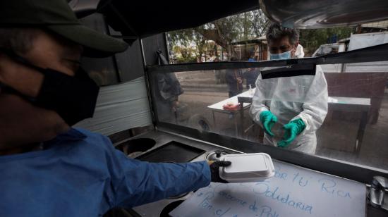 Personas preparan almuerzos, el martes 30 de junio, para ayudar a familias afectadas por la pandemia de la Covid-19 en la comuna de Conchalí en Santiago. 