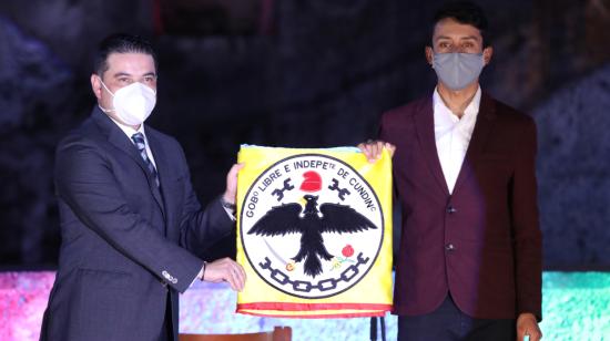 Nicolás García, gobernador de Cundinamarca, sostiene la bandera de Cundinamarca con el colombiano Egan Bernal, campeón del Tour de Francia, durante un homenaje de las autoridades locales, antes de su viaje a la temporada ciclista europea, el 16 de julio de 2020.