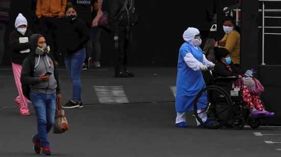 Ciudadanos esperan información de sus familiares contagiados con Covid-19, en las afueras del Hospital Iess del Sur, 22 de julio de 2020.