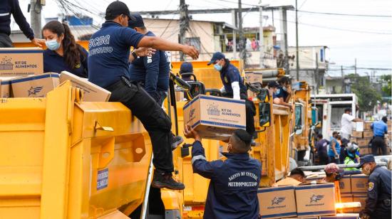 Guardias metropolitanos y efectivos de la Armada colaboran en la entrega de kits de alimentos del Municipio de Guayaquil, el 29 de julio de 2020. 