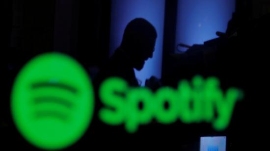 Un corredor de bolsa se refleja en una pantalla con el logo de Spotify, en la Casa de Valores de Nueva York, en abril de 2018.