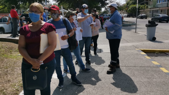 Un trabajador de CNEL explica a los clientes que no es necesario hacer reclamos de manera personal este 3 de agosto de 2020.