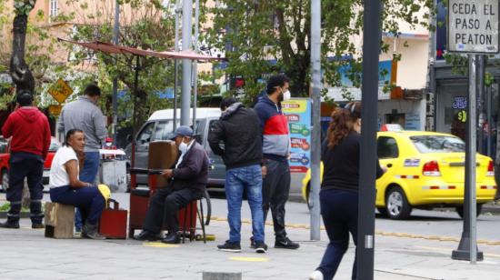 Personas caminan y conversan sobre la avenida Amazonas, en el norte de Quito, el 14 de julio de 2020.