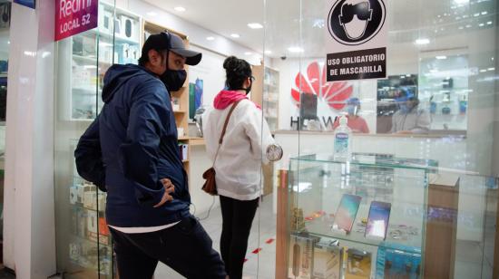 Personas en un local de celulares en un centro comercial del norte de Quito, en junio de 2020. 