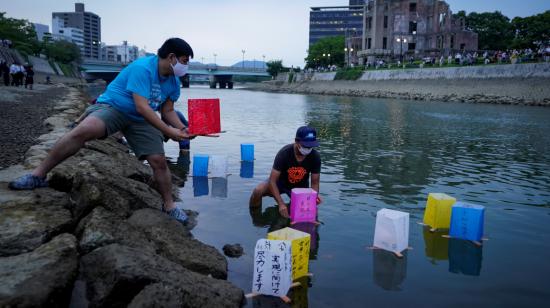 Personas ponen linternas de papel en el río Motoyasu cerca de la cúpula de la bomba atómica en el Parque Memorial de la Paz en oración por las víctimas del araque de 1945 en Hiroshima, el 6 de agosto de 2020.