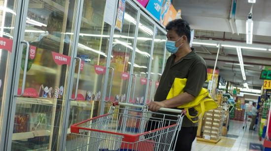 Foto referencial. Un hombre en Beijing mira a productos congelados en un supermercado de la capital China, el 13 de agosto de 2020.