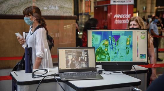 Un trabajador del aeropuerto de Milán (Italia) revisa la temperatura de los pasajeros, como medida de prevención ante el coronavirus, el 12 de agosto de 2020. 