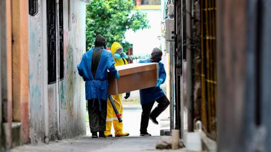 Personal de una funeraria traslada el ataúd de una persona fallecida, supuestamente a causa del coronavirus, el 14 de agosto de 2020 en Quito.