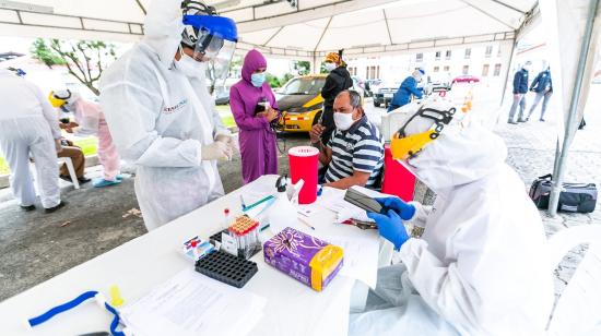 Un trabajador de la salud  realiza una prueba de Covid-19 a un ciudadano en una clínica temporal en Guayaquil, el 20 de julio de 2020.