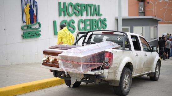 Empleados de una funeraria recogen al ataúd con un fallecido por Covid-19, en el hospital Ceibos del IESS, el 1 de abril de 2020.