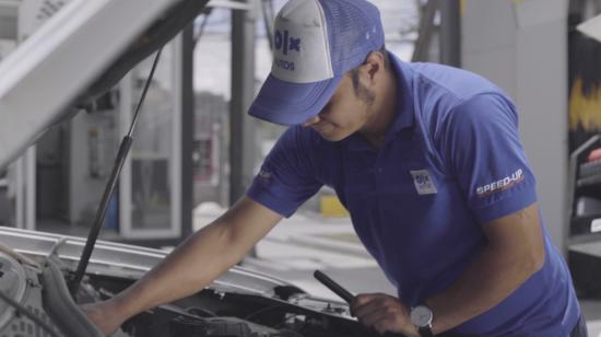 Una trabajador de OLX en uno de sus talleres revisando un vehículo usado. 