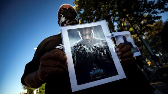 Un hombre sostiene una foto del actor Chadwick Boseman, que falleció a sus 43 años, durante una vigilia en Los Ángeles el 29 de agosto de 2020.