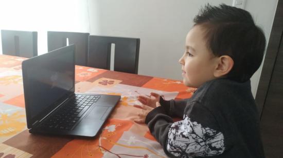 Niño estudia desde un computador.
