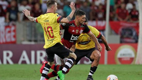 Los jugadores de Barcelona cubren al volante de Flamengo Giorgio de Arrascaeta, en el partido por Copa Libertadores, el 12 de marzo de 2020.