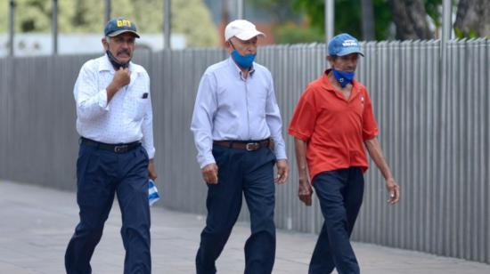 Tres hombres caminan en las calles de Guayaquil, el 15 de septiembre de 2020, tras la terminación del Estado de Excepción.