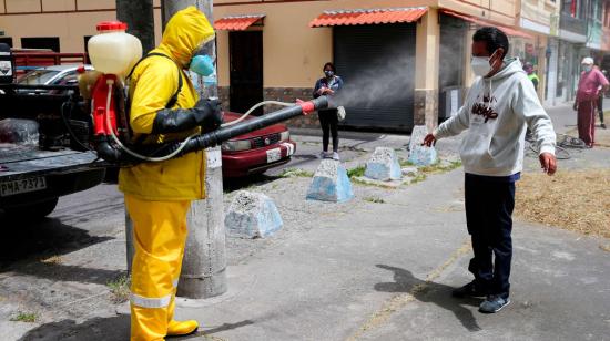 Personal sanitario de Quito desinfecta a un hombre, el 20 de agosto de 2020.