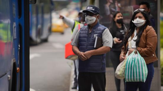 Personas esperan un bus en una parada ubicada en la avenida Naciones Unidas, norte de Quito, el 18 de septiembre de 2020.