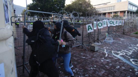 Mujeres intentan quitar las barreras que resguardan la Asamblea Nacional en Quito, el 28 de septiembre de 2020.