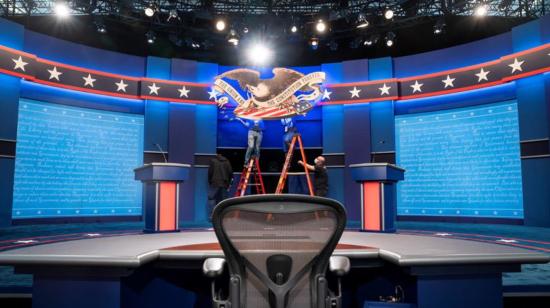 Trajadores arreglan el set donde se realizará el primer debate entre Donald Trump y Joe Biden este 29 de septiembre de 2020.