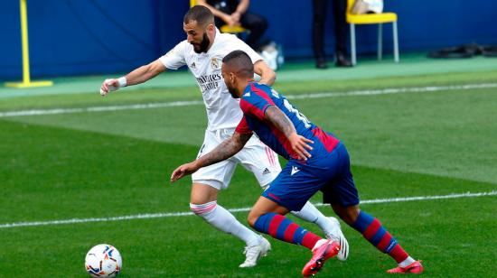 El delantero francés del Real Madrid Karim Benzema pelea un balón con el defensa portugués del Levante Rubén Vezo en el partido de La Liga, que se disputa este domingo 4 de octubre de 2020.