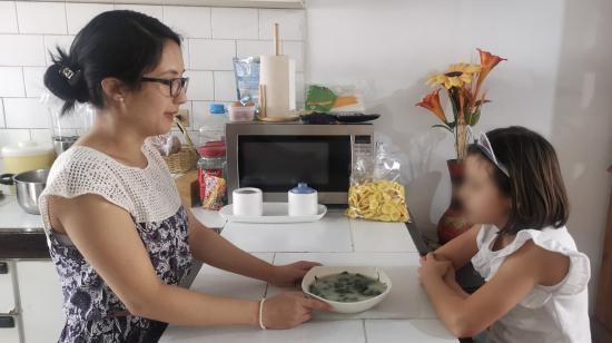 Una mamá sirve la comida a su hija en Quito, el 10 de octubre de 2020.