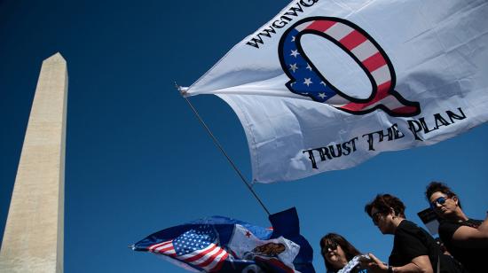 Grupo de manifestantes en Washington, Estados Unidos, con una bandera de QAnon.