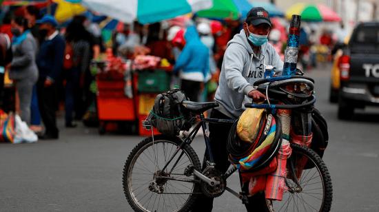 Un hombre empuja una bicicleta en una calle cercana al mercado de Riobamba el 16 de septiembre de 2020. 