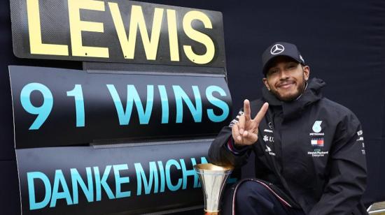 Lewis Hamilton posa junto al cartel que retifica sus 91 victorias en la Fórmula 1, las mismas que Schumacher.