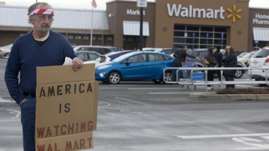 Foto de archivo. Un hombre sostiene un cartel en el que se lee "Walmart, América te está observando" durante una protesta en Danbury, Connecticut, el 15 de enero de 2013. 