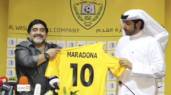 Diego Armando Maradona posando con su camiseta del Al-Wasl, junto al presidente del club, Marwan Bin Bayat durante una rueda de prensa donde se presentó como nuevo entrenador en el hotel Jumeirah Zabeel Saray, el 11 de septiembre de 2011, en Dubai.