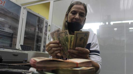 Una mujer cuenta billetes entre los que hay dólares estadounidenses, el 28 de octubre de 2020, en San Cristóbal (Venezuela).